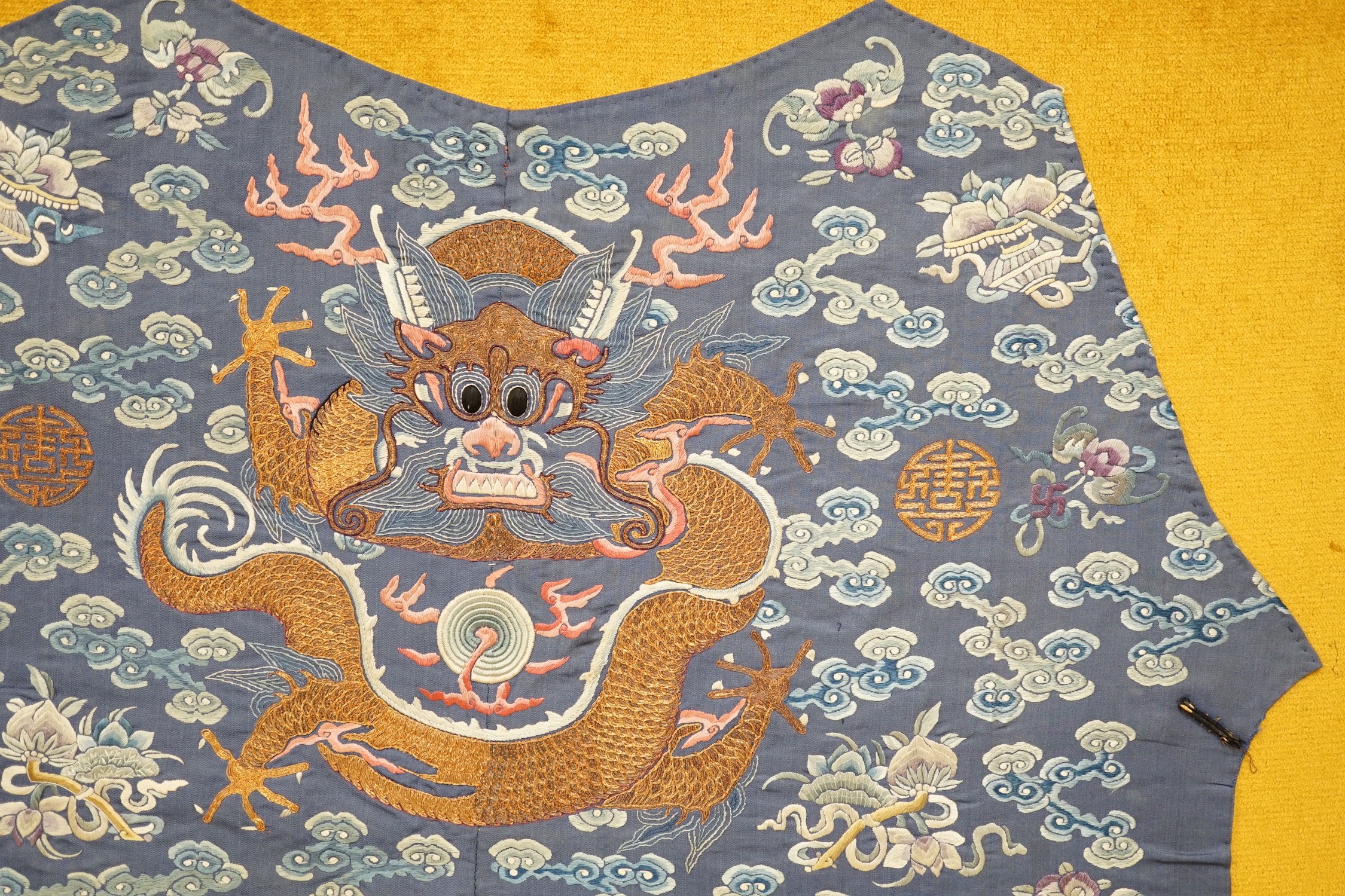 An early 20th century Chinese silk embroidered panel, from a robe, embroidered in metallic and coloured threads as dragons and auspicious symbols